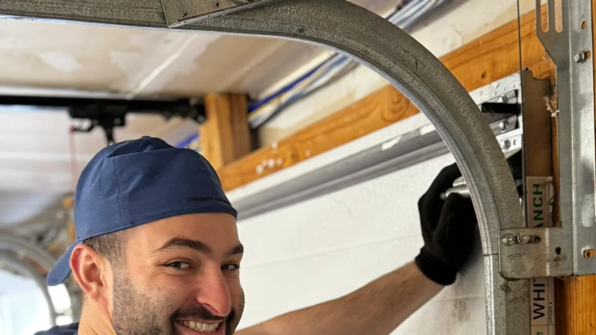Technician working beside a residential garage door track