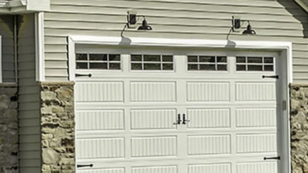 White carriage-style garage door with decorative windows and black hardware