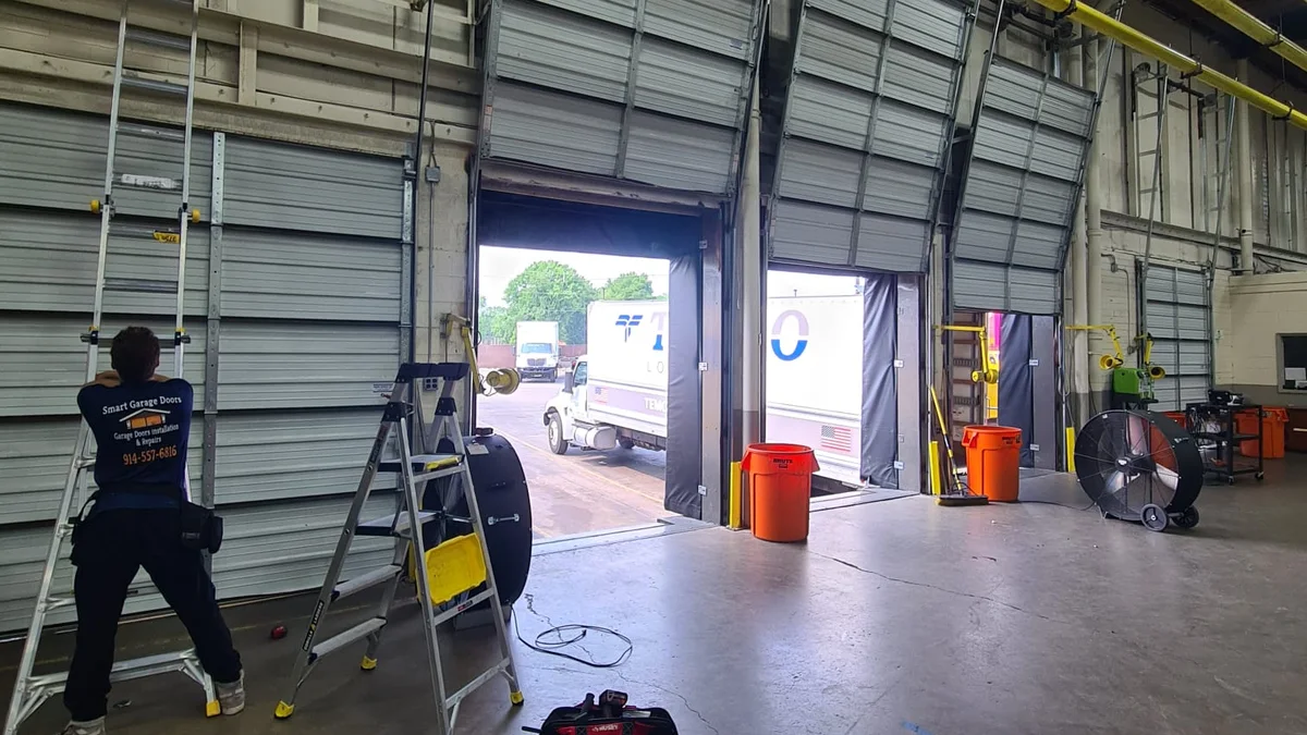 Technician working inside an industrial building with an overhead door