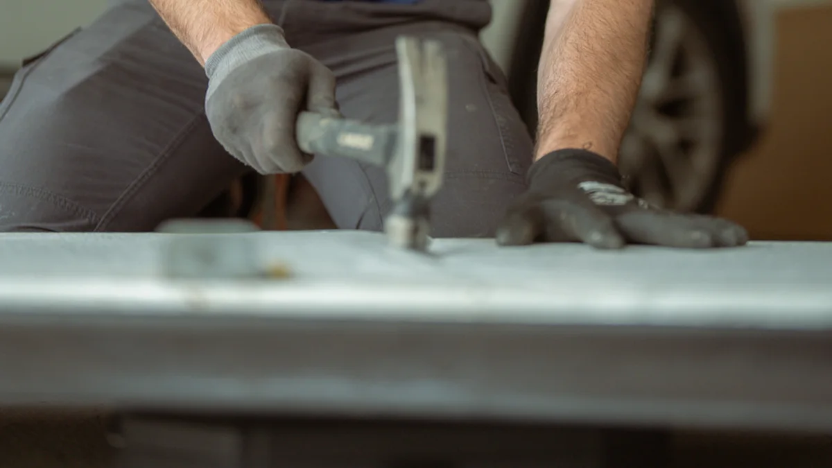 Technician preparing a garage door panel on a workbench