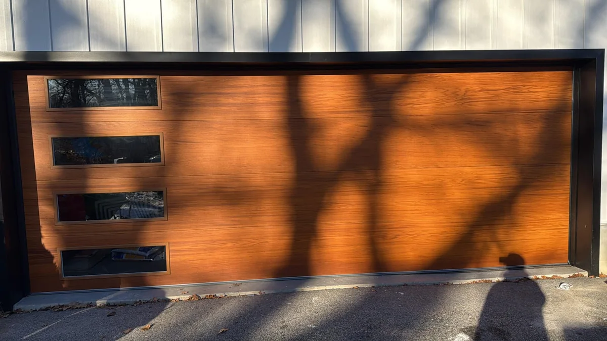 Contemporary wood-finish garage door with dark window panels