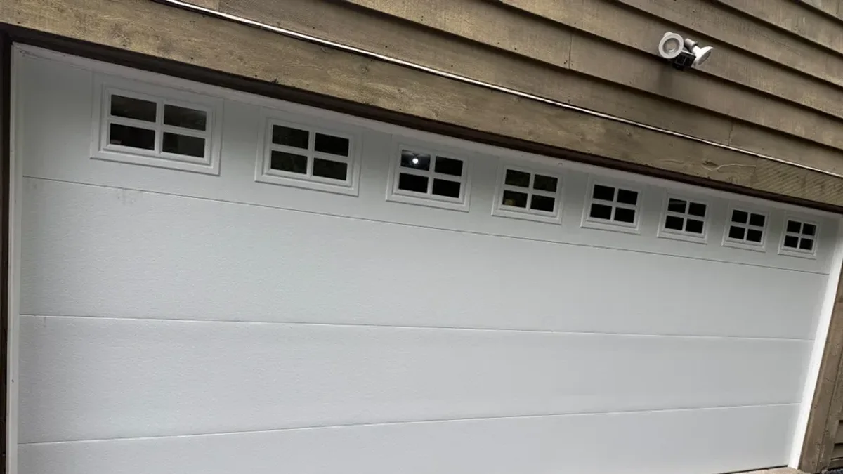 Wide white garage door with a row of window inserts