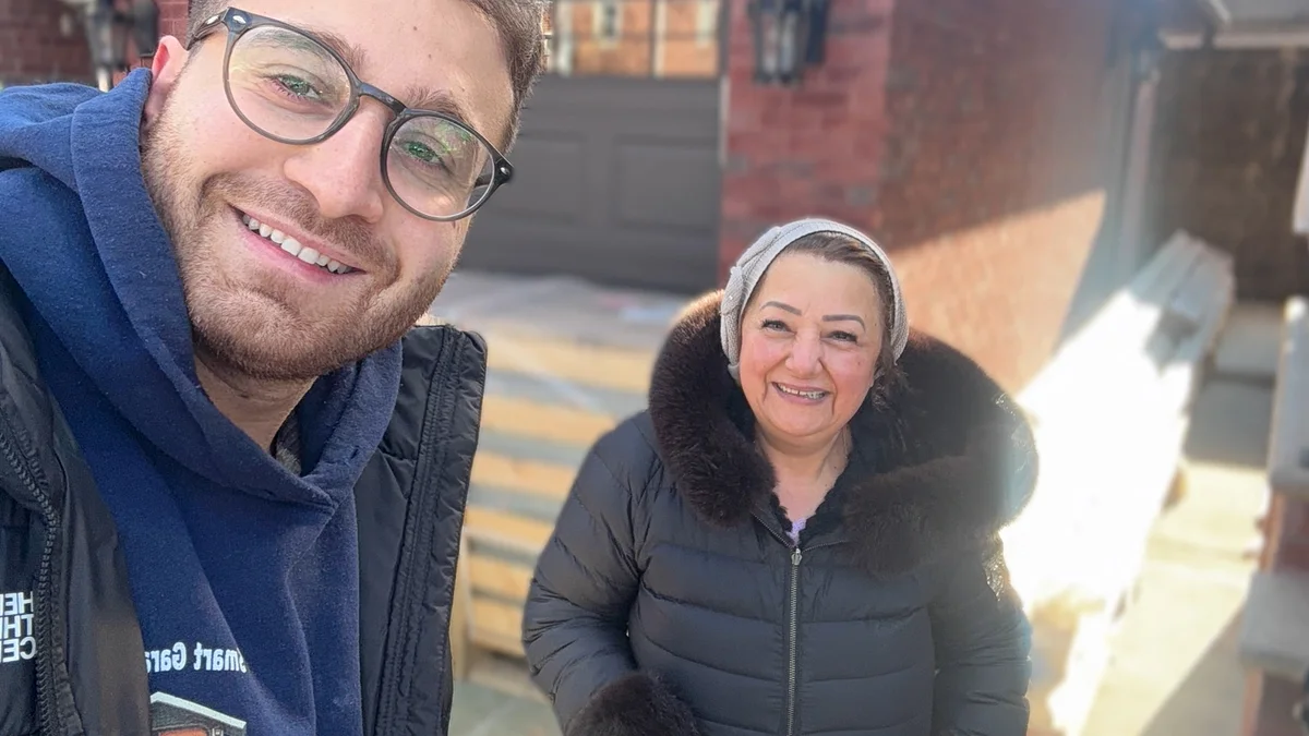 Two people beside a residential garage after a service visit