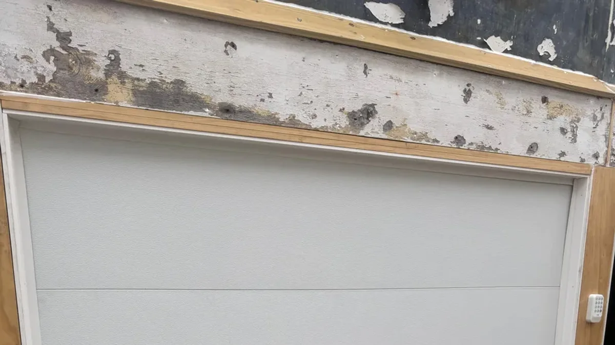 New flush-panel white garage door beneath an unfinished header