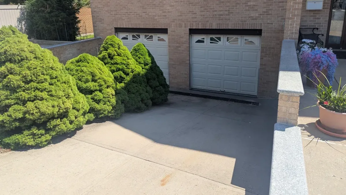 White garage doors with decorative windows on a brick building