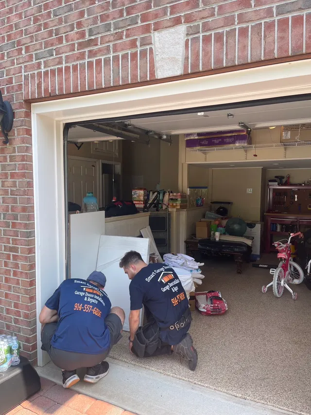Smart Garage Doors two-man team at a residential brick home installing a garage door