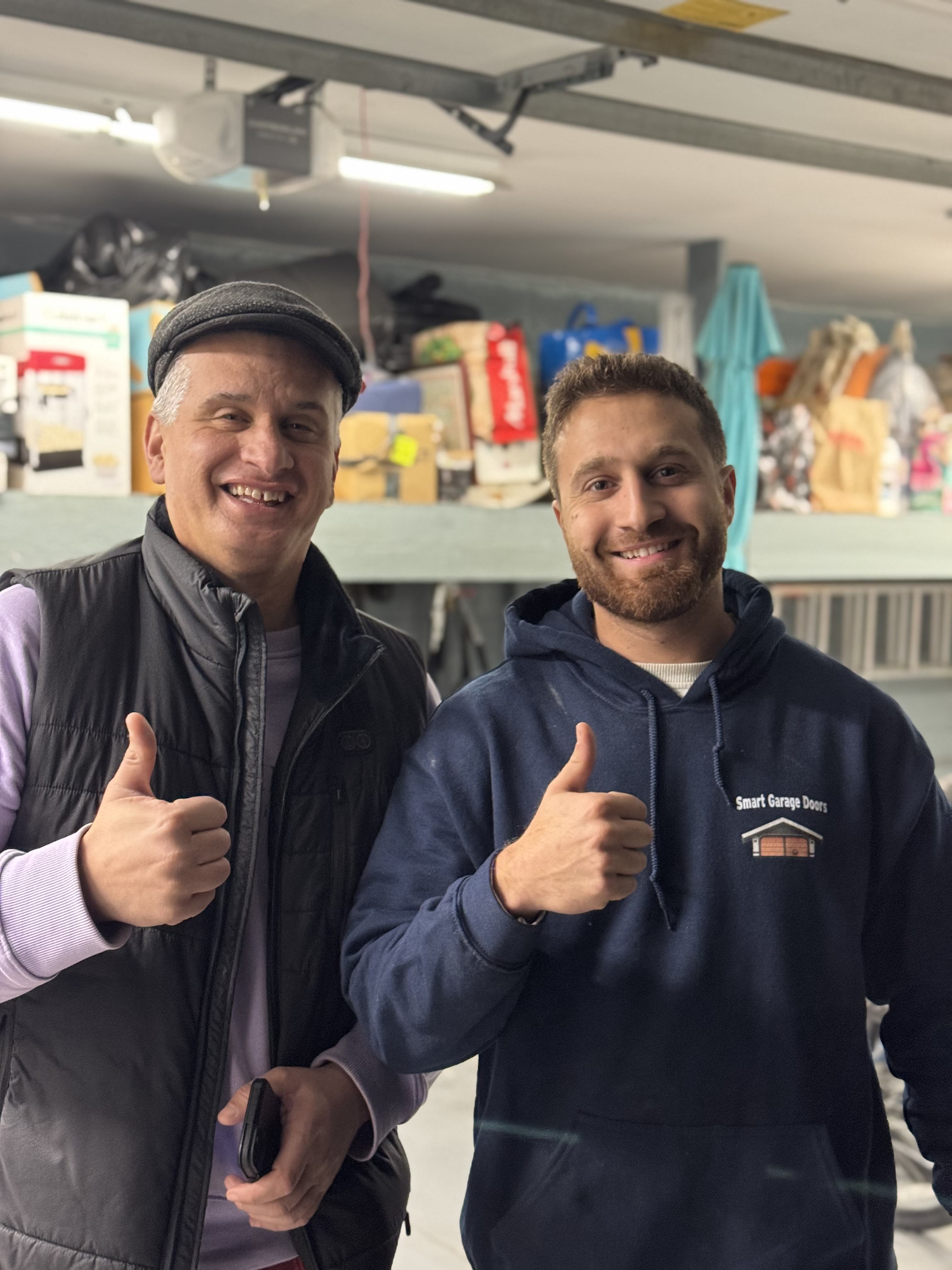 Happy customer giving thumbs up with Smart Garage Doors technician after repair