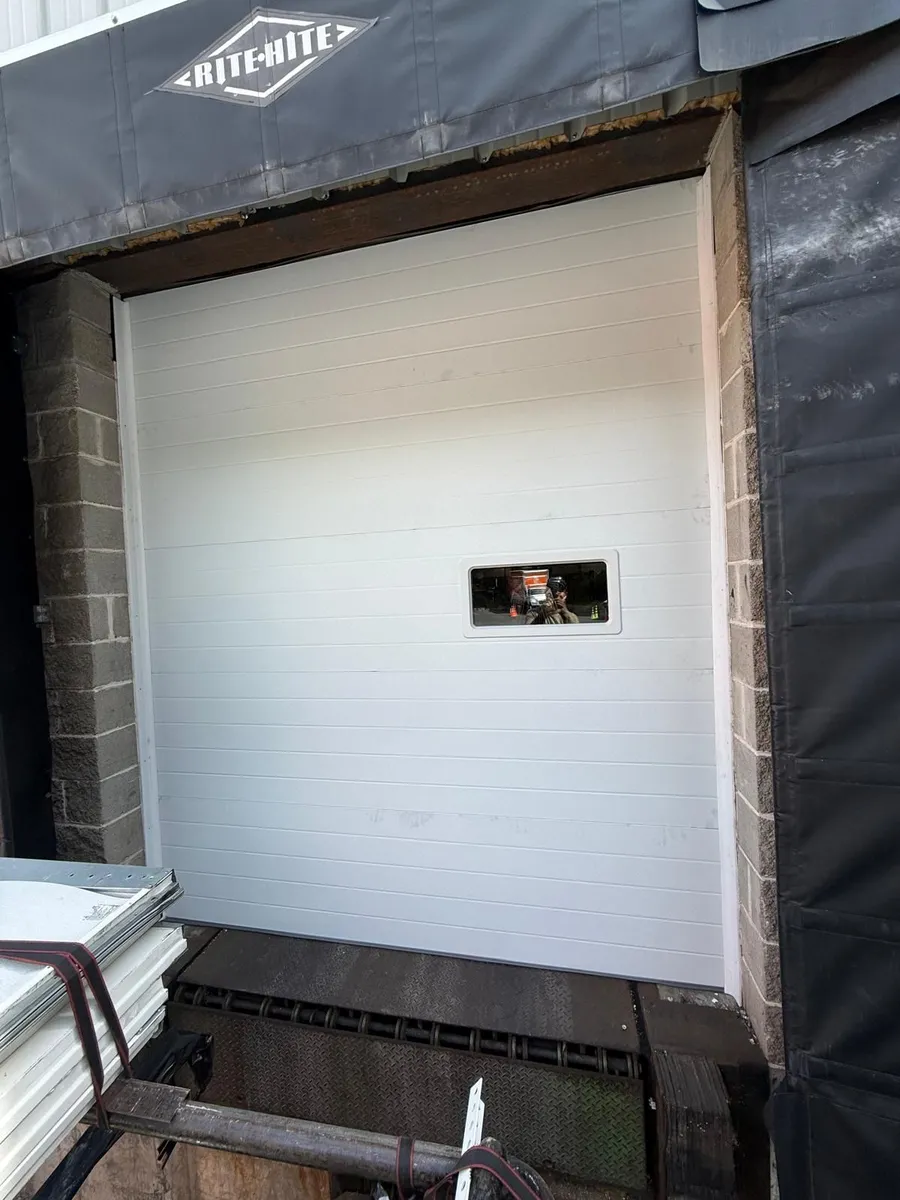 White insulated commercial loading dock door installed inside a dock shelter at a Queens, NY warehouse